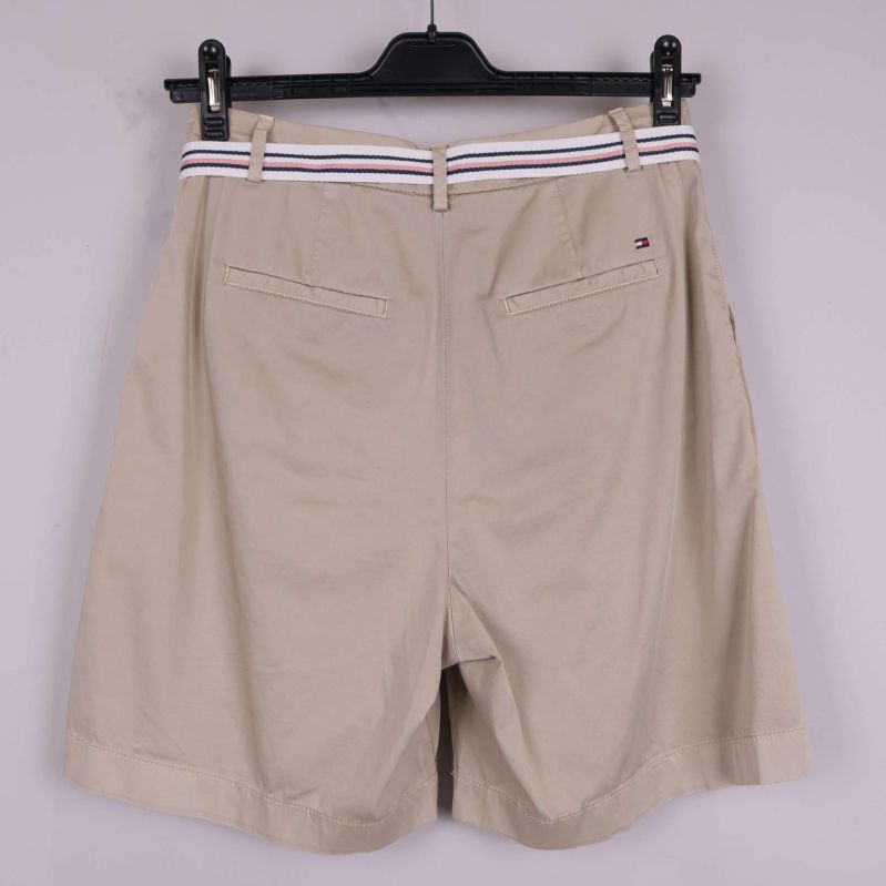 Baksida av beige shorts med fickor och logotyp