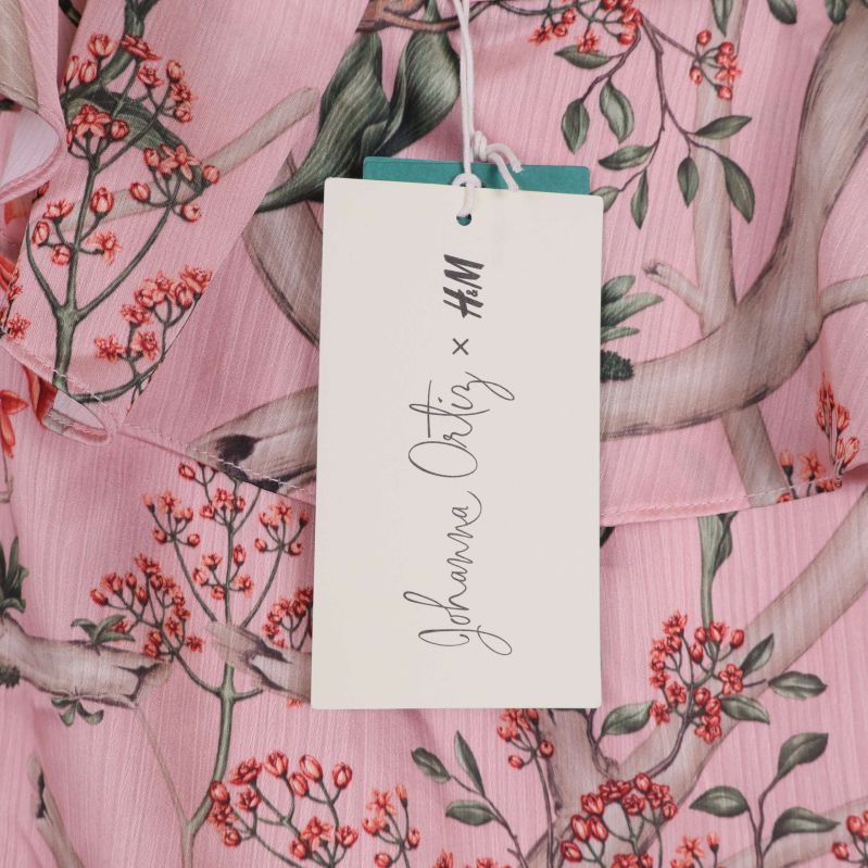 Närbild på hängande tagg med text Johanna Ortiz x H&M
