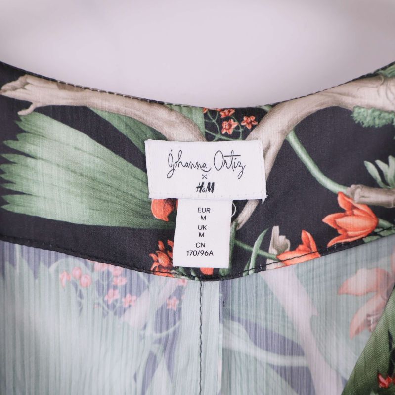 Närbild på etikett med storlek och samarbete H&M x Johanna Ortiz