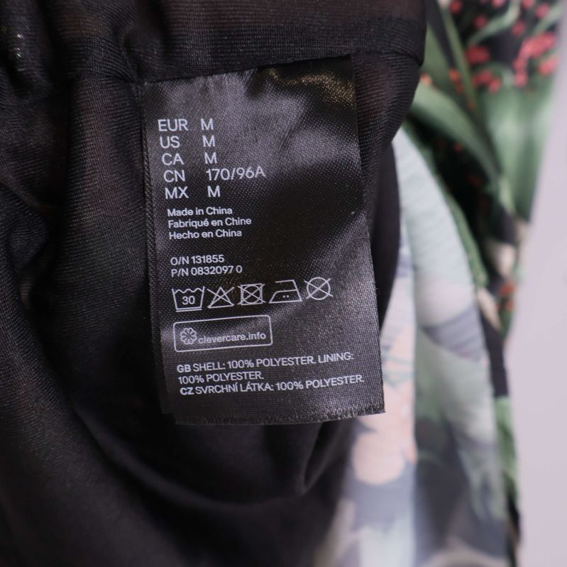 Tvättrådsetikett som visar 100% polyester material