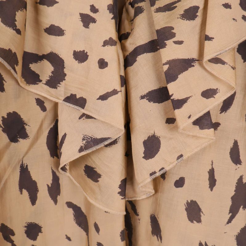 Närbild på volang och djurmönstrad textil