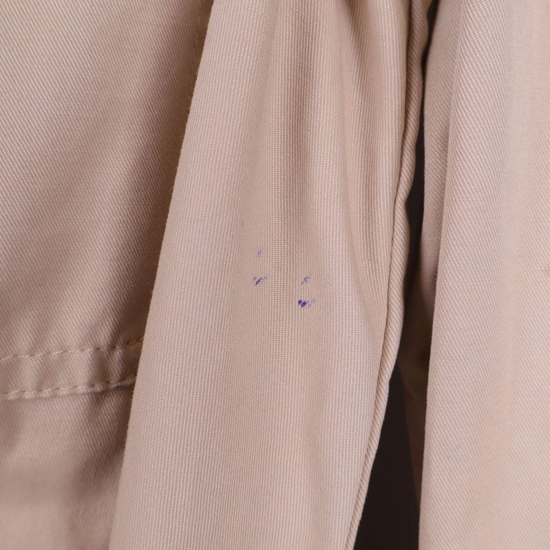 Små bläckfläckar på ena ärmen av beige skjortklänning