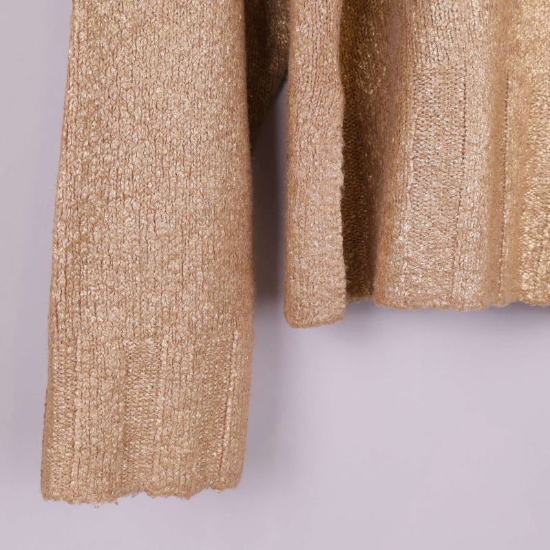 Närbild nedre ärm på beige glittrig tröja