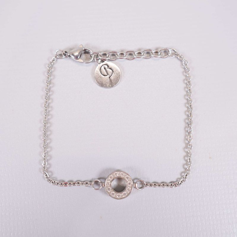 Silverfärgat armband med cirkeldetalj och berlock