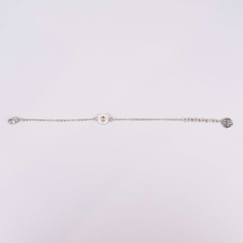 Helt utsträckt silverfärgat armband på ljus bakgrund