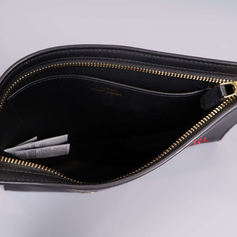 Inuti svart clutch med dragkedja och foder i svart