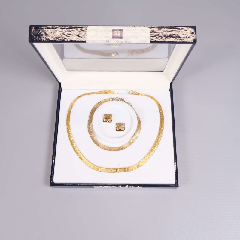Öppet smyckeset med halsband och örhängen placerade i vit ask