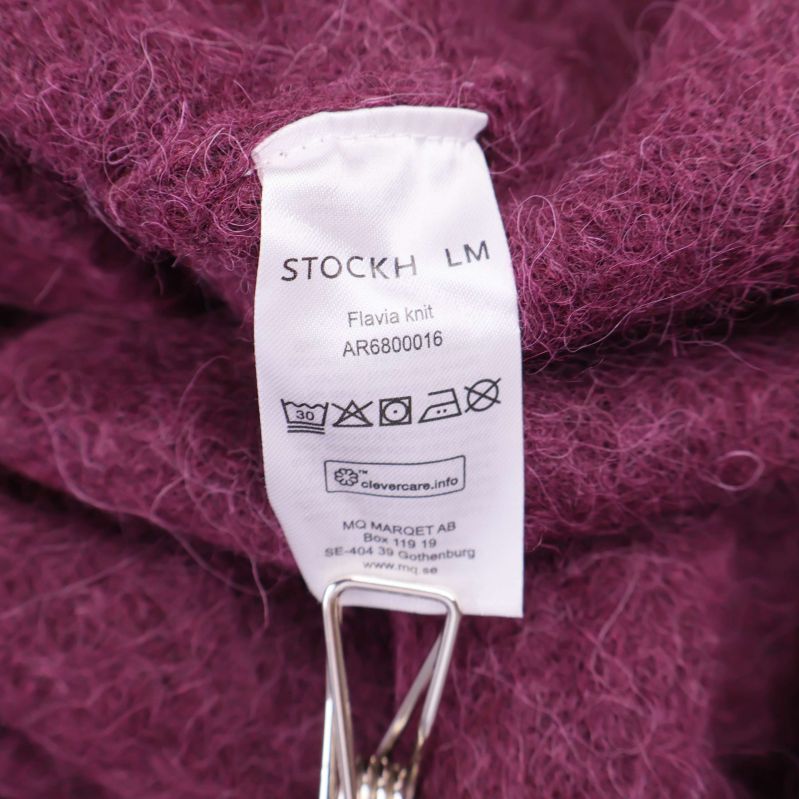 Tvättrådsetikett med STOCKH LM och tvättsymboler
