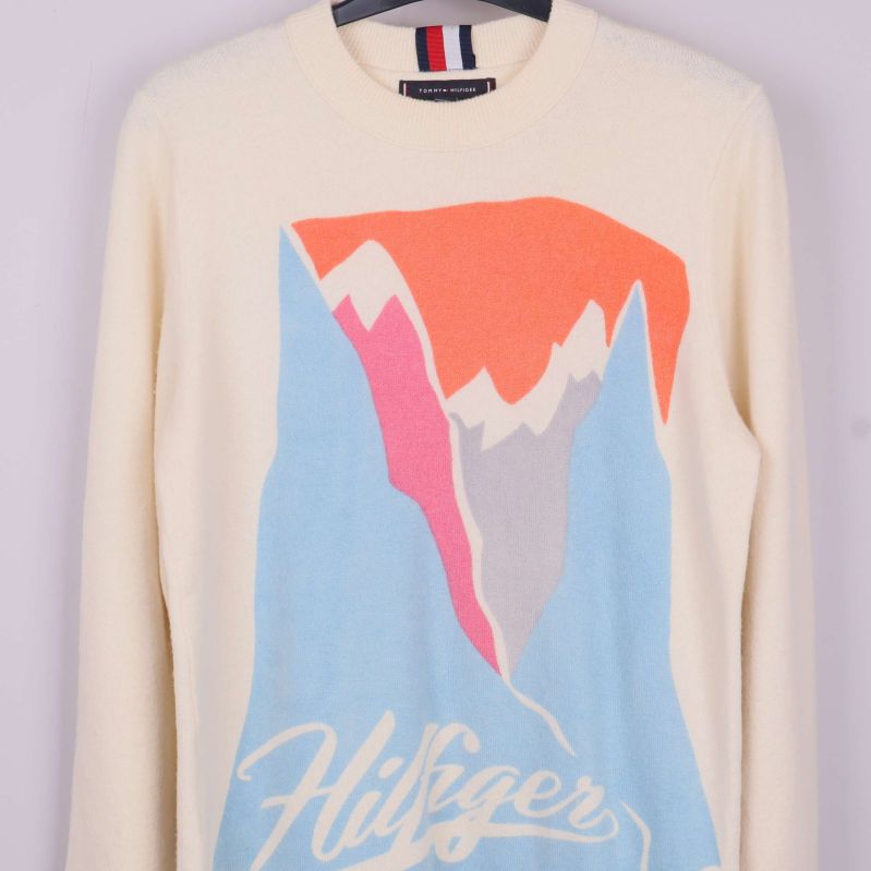 Närbild på färgglatt bergmotiv och Hilfiger-tryck på tröjan