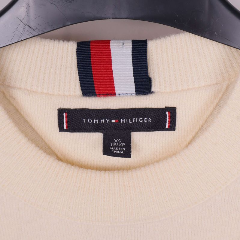 Närbild på halsetikett med Tommy Hilfiger-logotyp och randig remsa