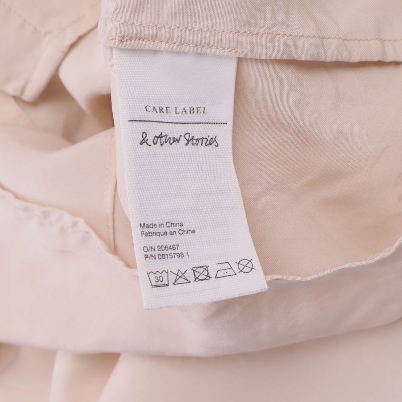 Tvättrådsetikett från & Other Stories i beige blus
