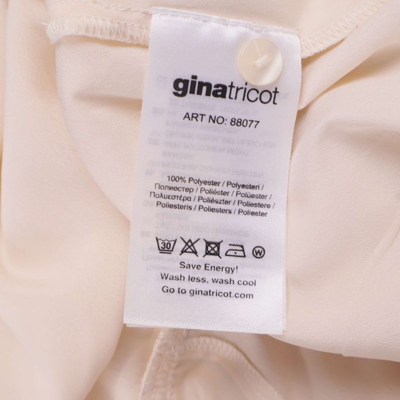 Materiallapp med information: 100% polyester samt tvättsymboler