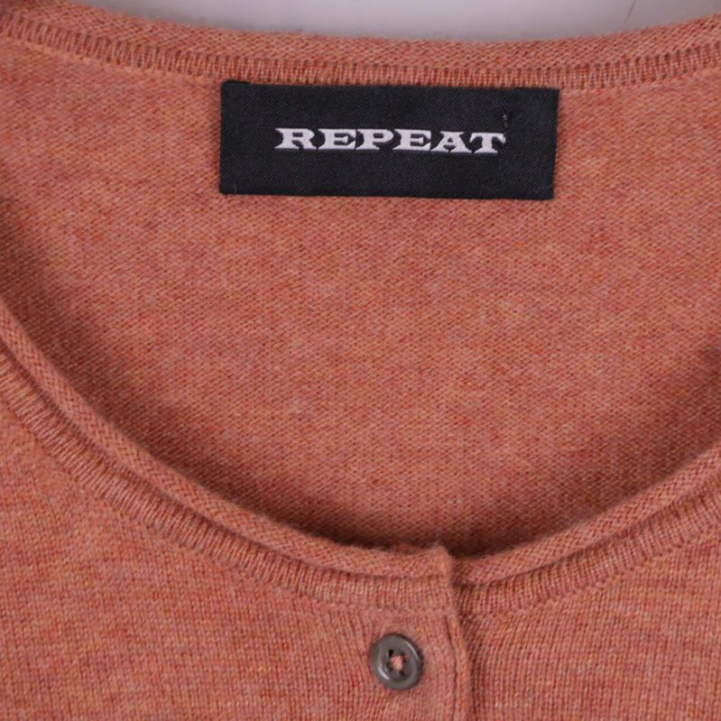 Närbild på Repeat logotyp och koftans halsringning