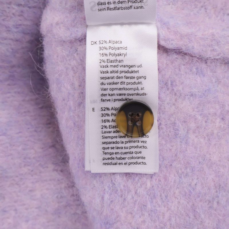 Materialetikett med sammansättning: 52% alpacka, 30% nylon, 16% akryl, 2% elastan
