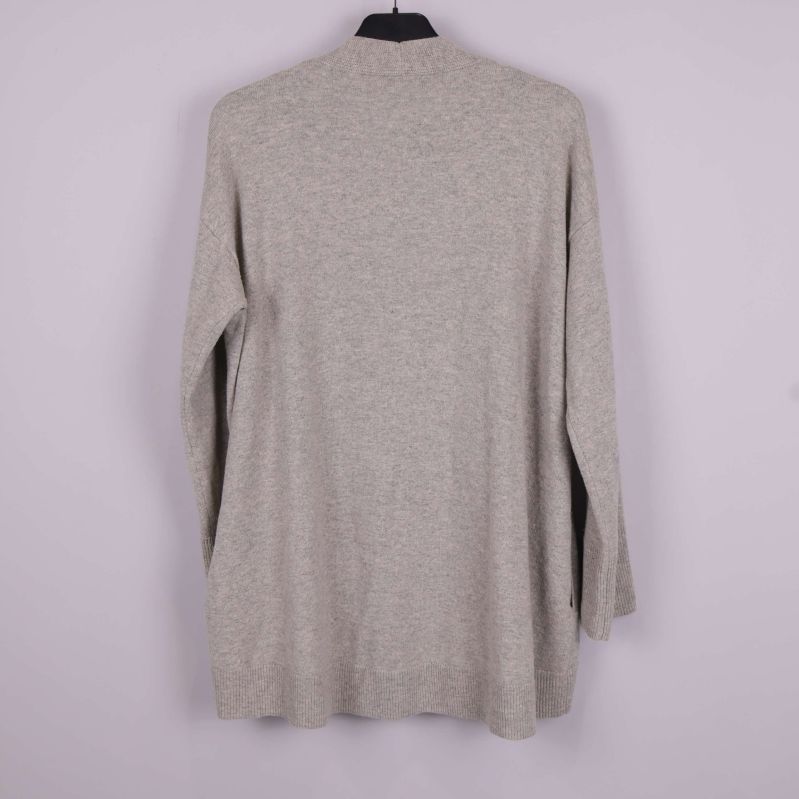 Baksidan av beige lång kofta upphängd på galge