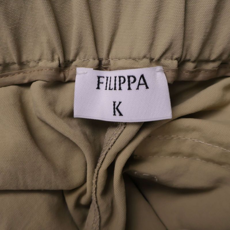 Närbild på Filippa K-logotyp i midjan
