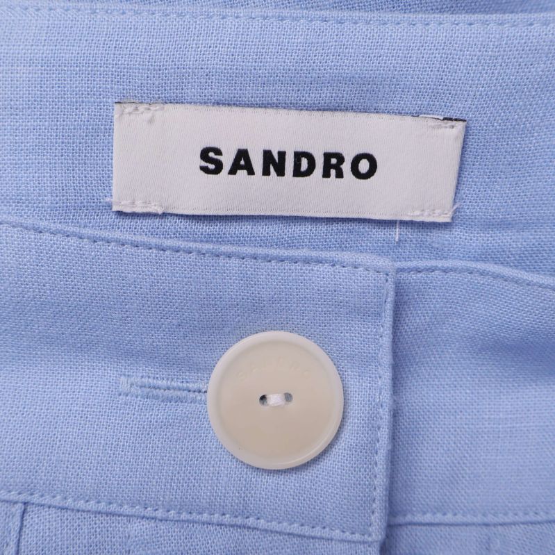 Närbild på Sandro-etikett och vit knapp i kjolen