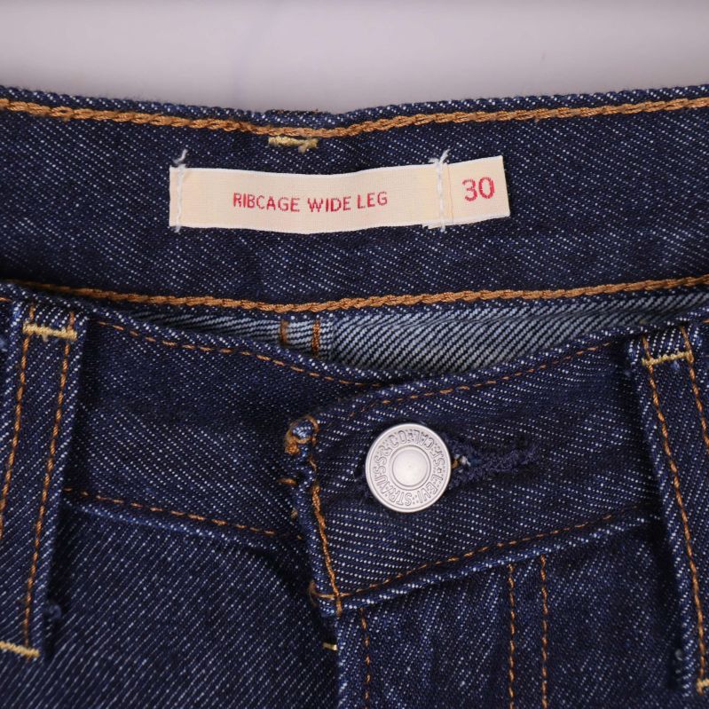 Etikett med texten Ribcage Wide Leg och storlek 30