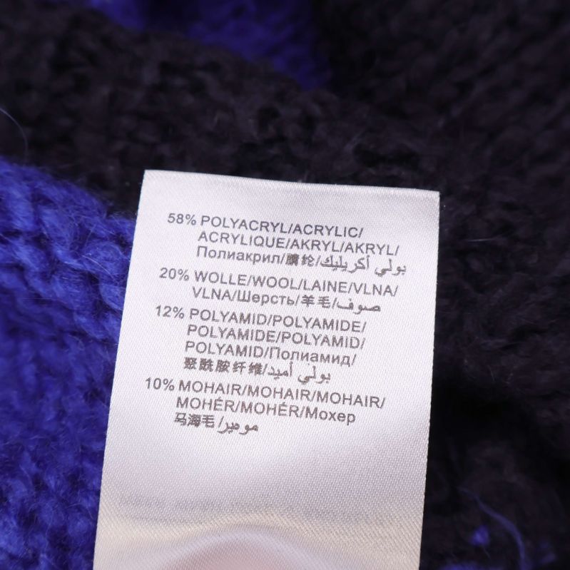 Materiallapp med 58 procent polyakryl, 20 procent ull, 12 procent polyamid och 10 procent mohair