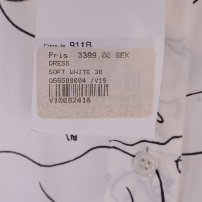 Prislapp med information om klänningen, färg Soft White och storlek 36