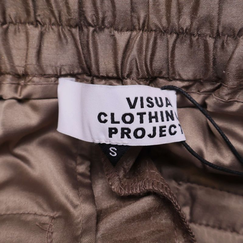 Närbild på varumärkestagg Visual Clothing Project och storlek S