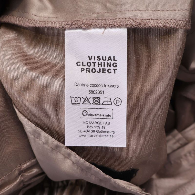 Materialetikett Visual Clothing Project med skötselråd