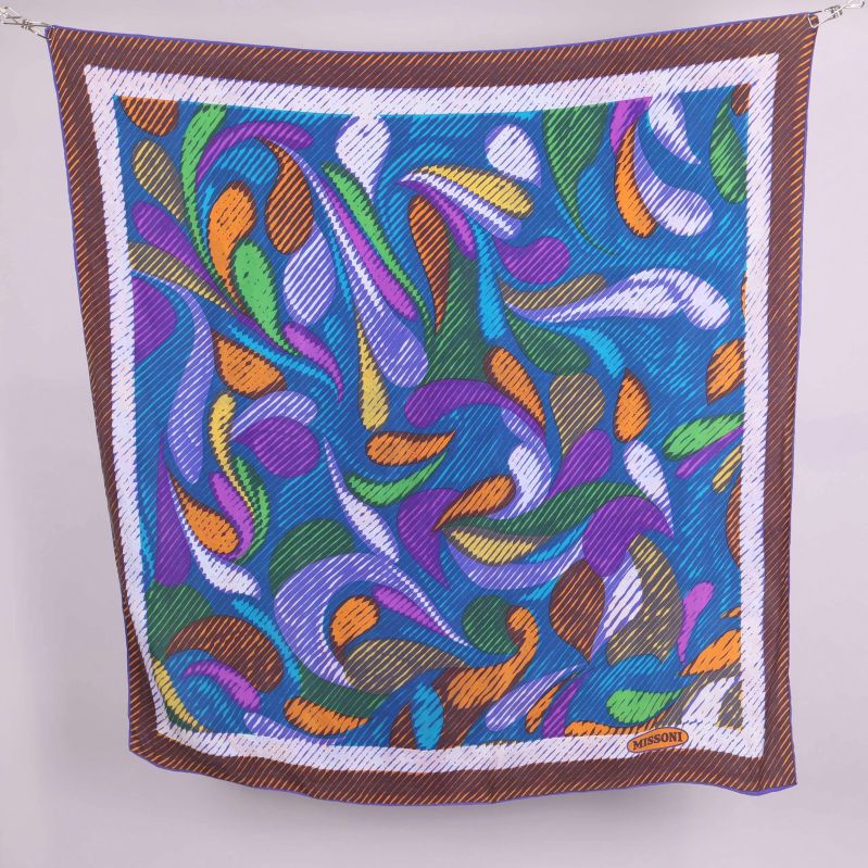 Stor fyrkantig scarf med grafiskt färgmönster mot vit bakgrund