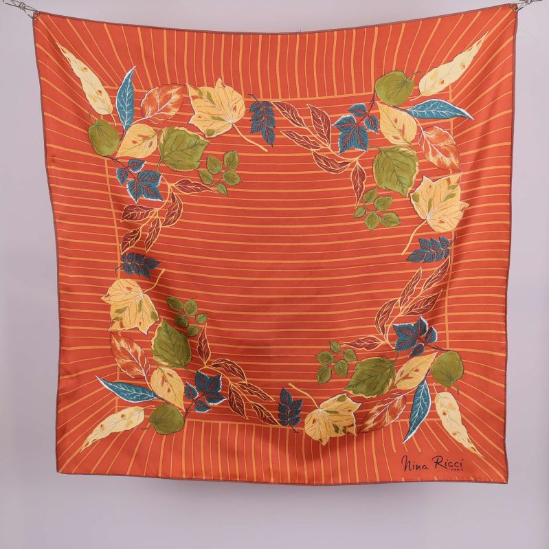 Kvadratisk scarf med orange botten och bladmotiv i olika färger
