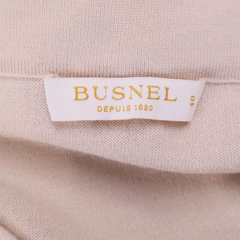 Busnel-etikett med texten 'DEPUIS 1920' insydd i kjolen