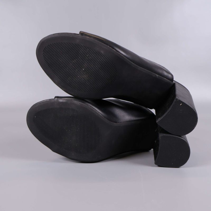 Undersidan av svarta slip-in sandaler med grepp
