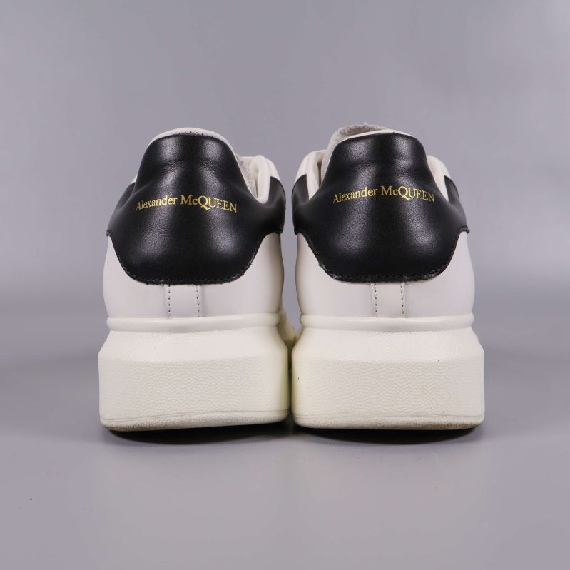 Baksida av sneakers med svart häl och guldtext