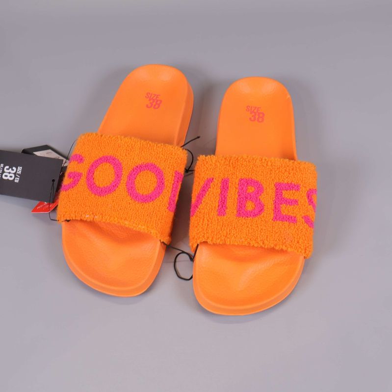 Slides ovanifrån med rosa text på orange frottérem
