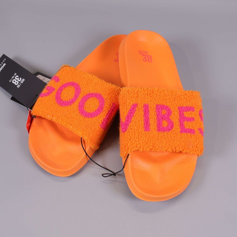 Närbild på slides med frotté och texten GOOD VIBES