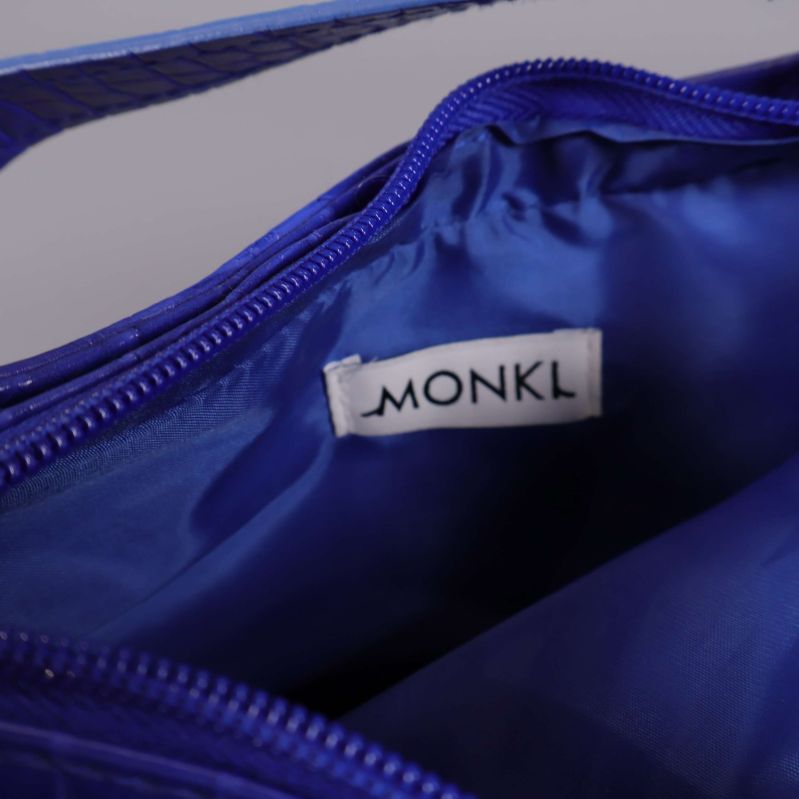 Närbild på Monki-logga inuti blå väska