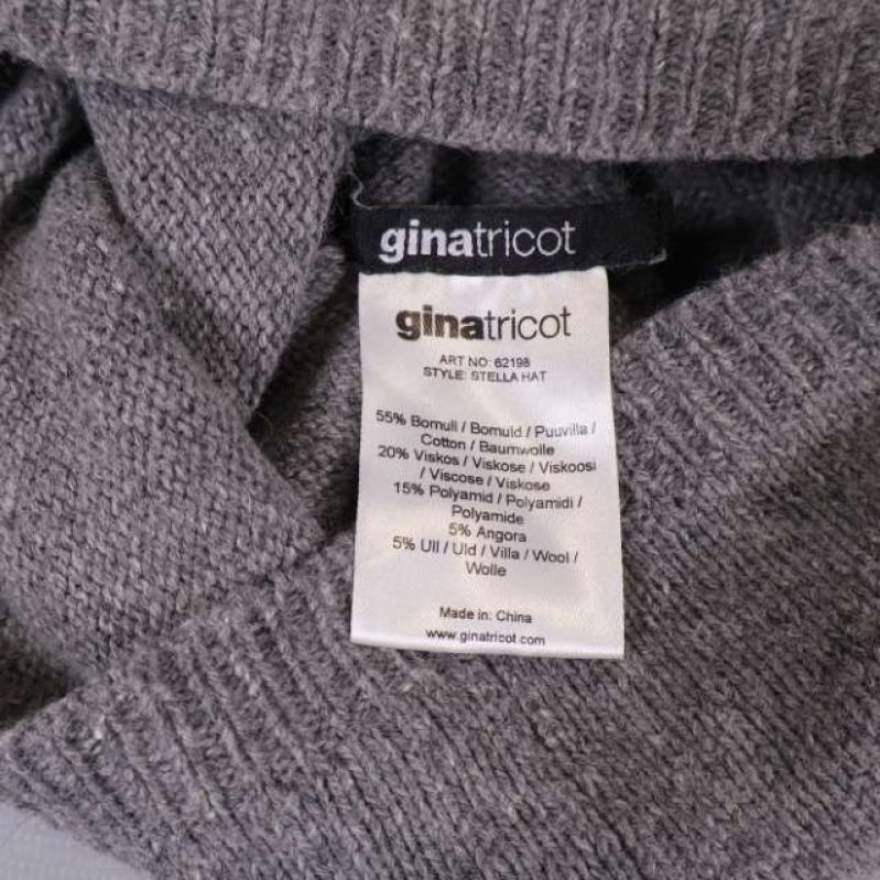 Material- och varumärkesetikett från Gina Tricot inuti mössan