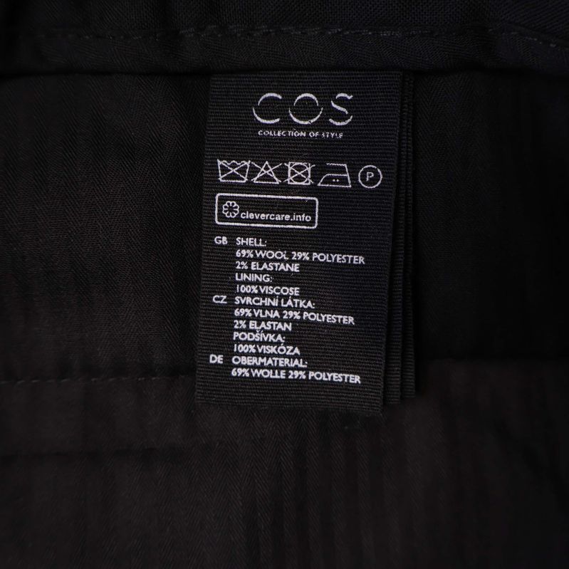 Materialetikett visar 69% ull, 29% polyester, 2% elastan