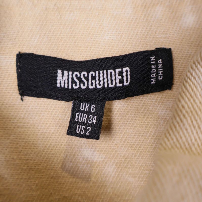 Storleksetikett med Missguided och storlekar UK 6 EUR 34 US 2