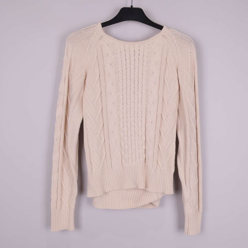 Framsidan av beige stickad tröja med struktur