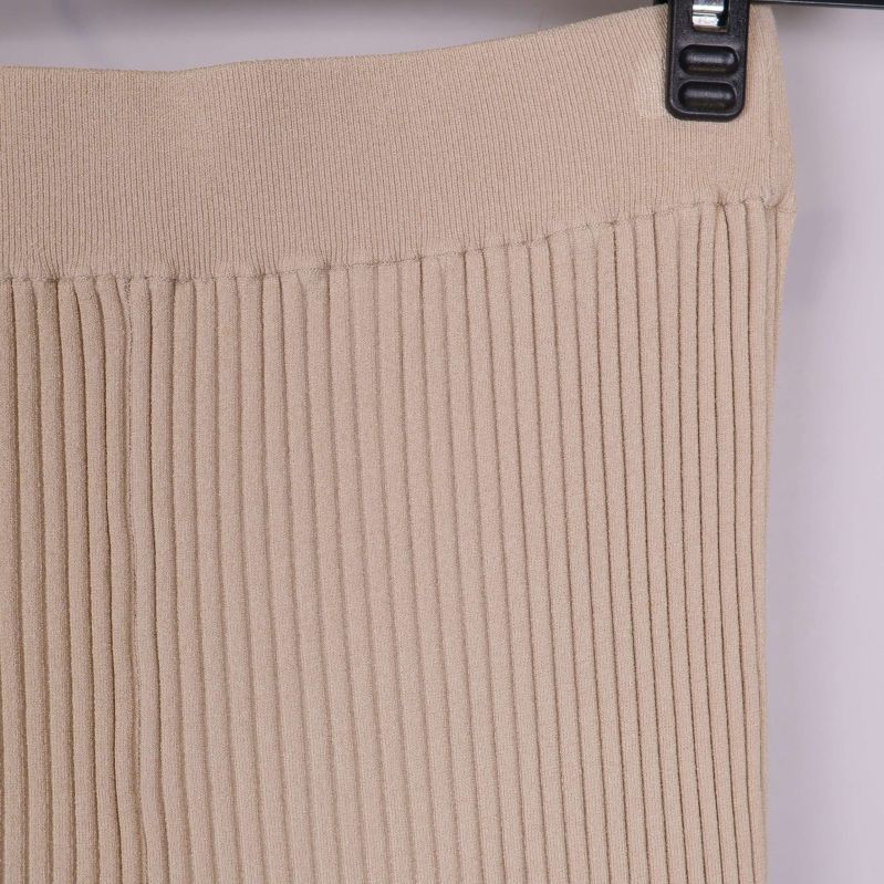 Närbild på ribbstickad midja i beige material