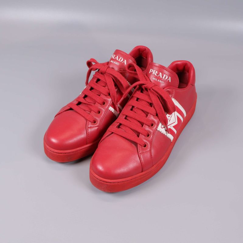 Röda sneakers med vit logga och röda snören