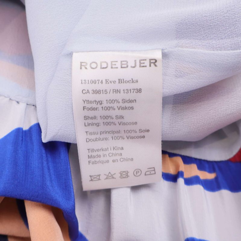 Materiallapp som visar 100% siden och fodret är 100% viskos