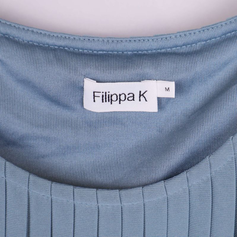 Närbild på Filippa K etikett i nacken på klänning