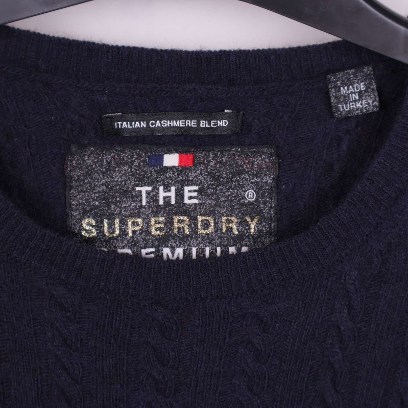 Närbild på halsringning med Superdry Premium etikett och cashmere blend