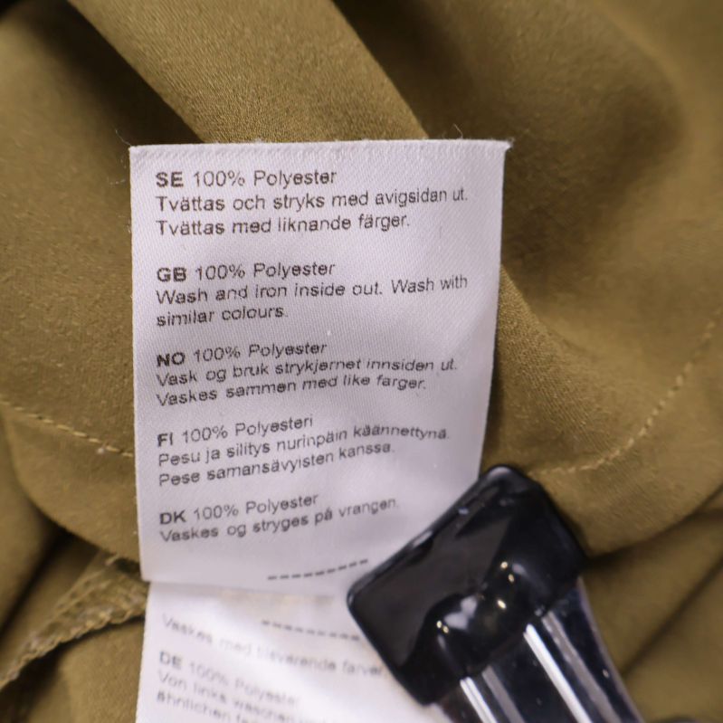 Materiallapp med texten 100% Polyester på flera språk