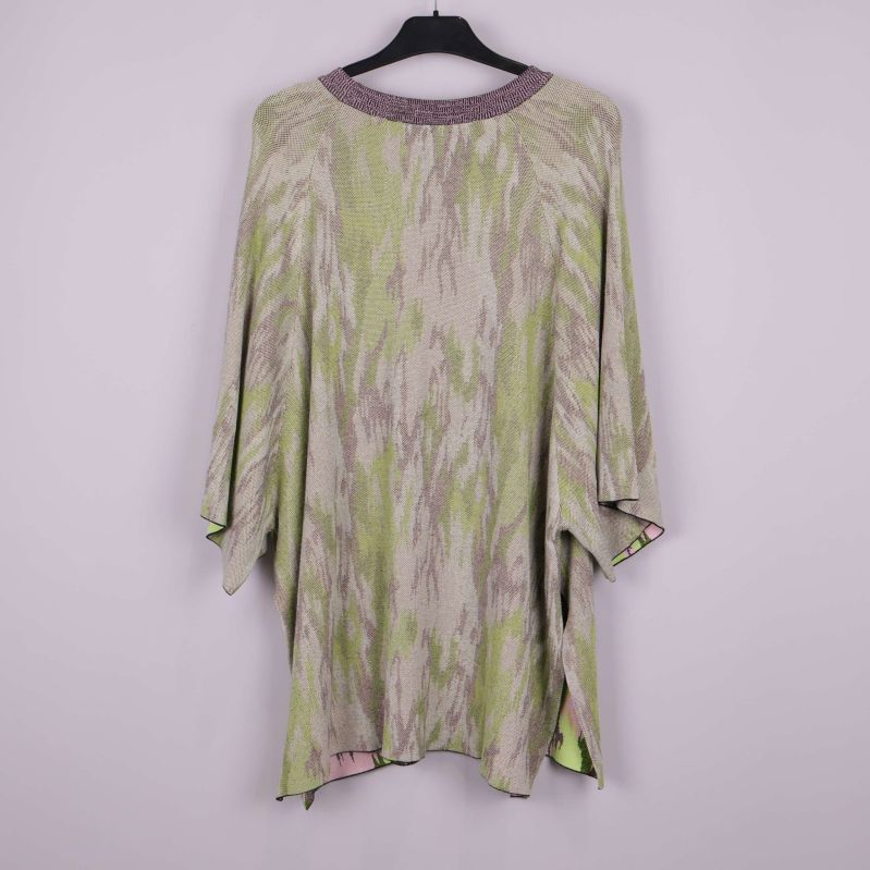 Poncho med grönt och beige mönster bakifrån på galge