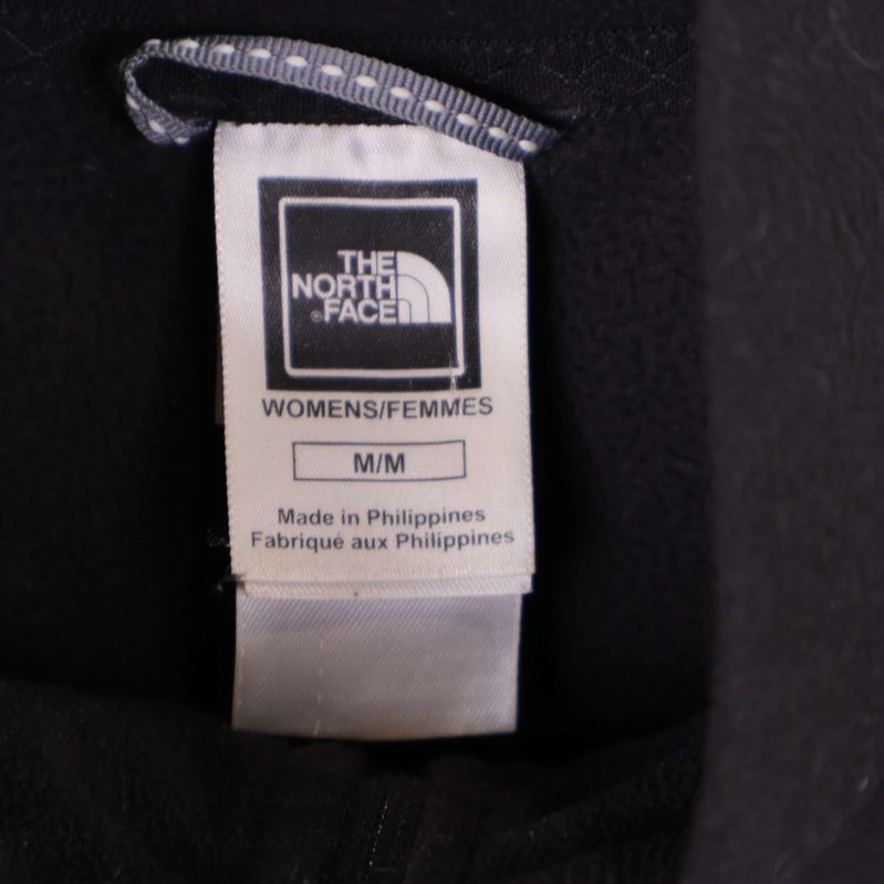 Nacketikett med The North Face logotyp och storleksangivelse M