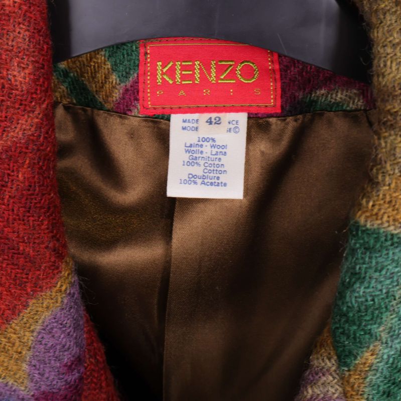 Närbild på Kenzo-märkesetikett och materiallapp