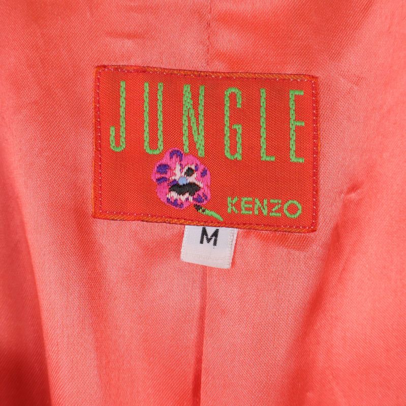Närbild på JUNGLE KENZO M etikett i orange foder