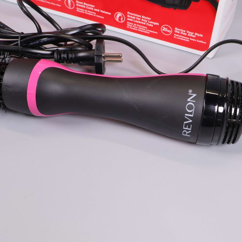 Handtag med Revlon-logga och rosa detalj syns i närbild