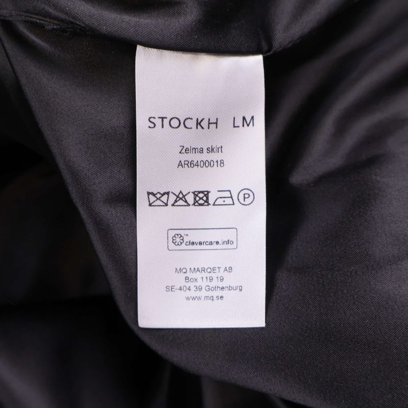 Vård- och produktetikett med texten STOCKH LM Zeira skirt